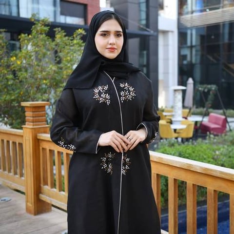 عباية لف باللون الاسود مزينة بشك بارز وقيطان على اطراف العباية والاكمام