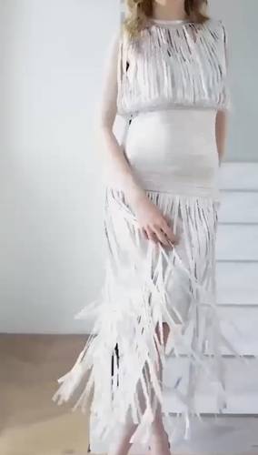 فستان سهرة أبيض بشرائط انسيابية بتصميم عصري وجذاب