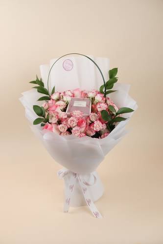 Elegant bouquet of roses with Coach Dream perfume for women