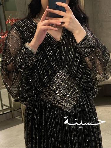 فستان أسود ترتر ذهبي بأكمام شفافة