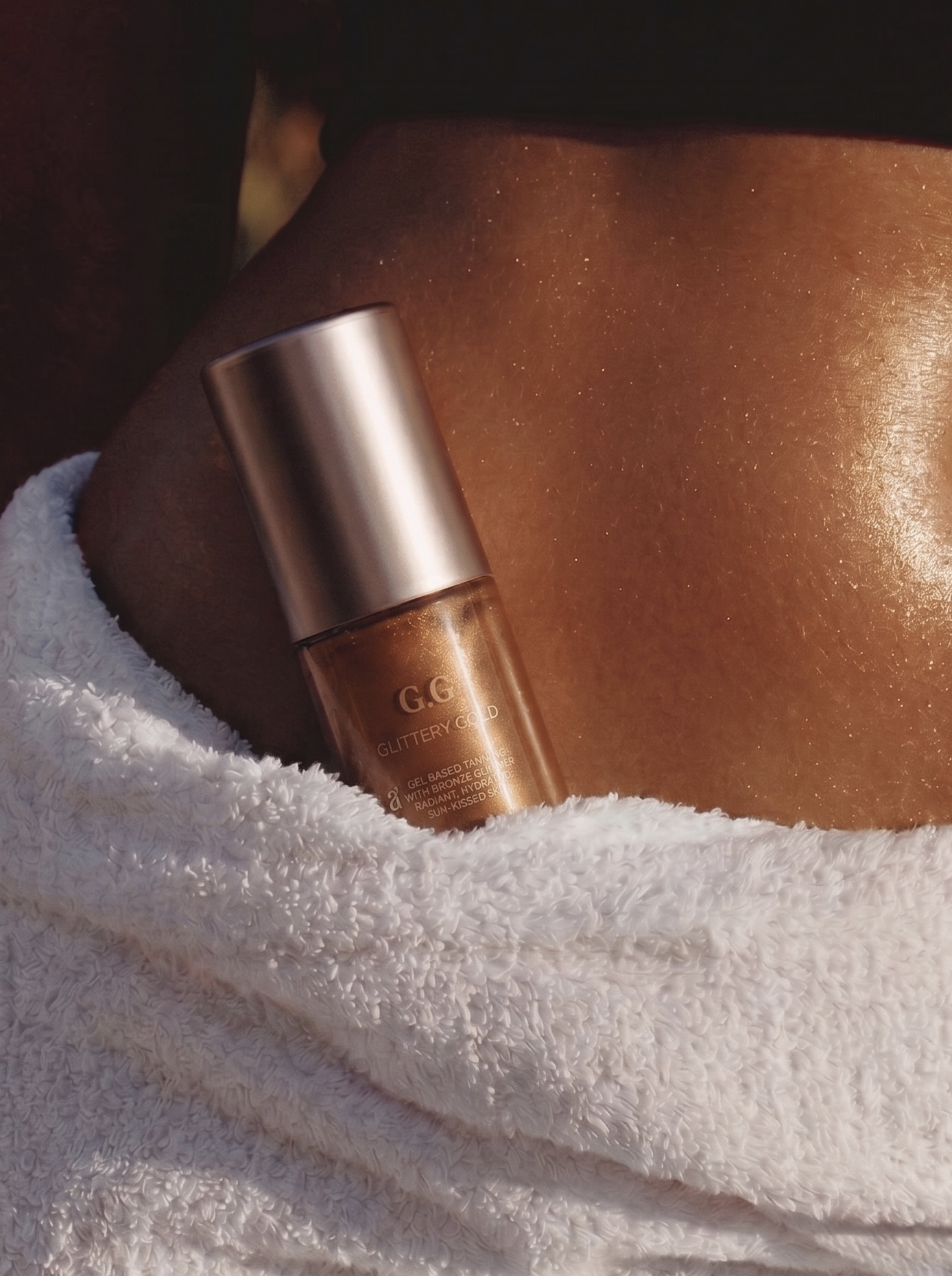 Amie Glow body oil in a luxury spa setting with a bronzing shimmer effect