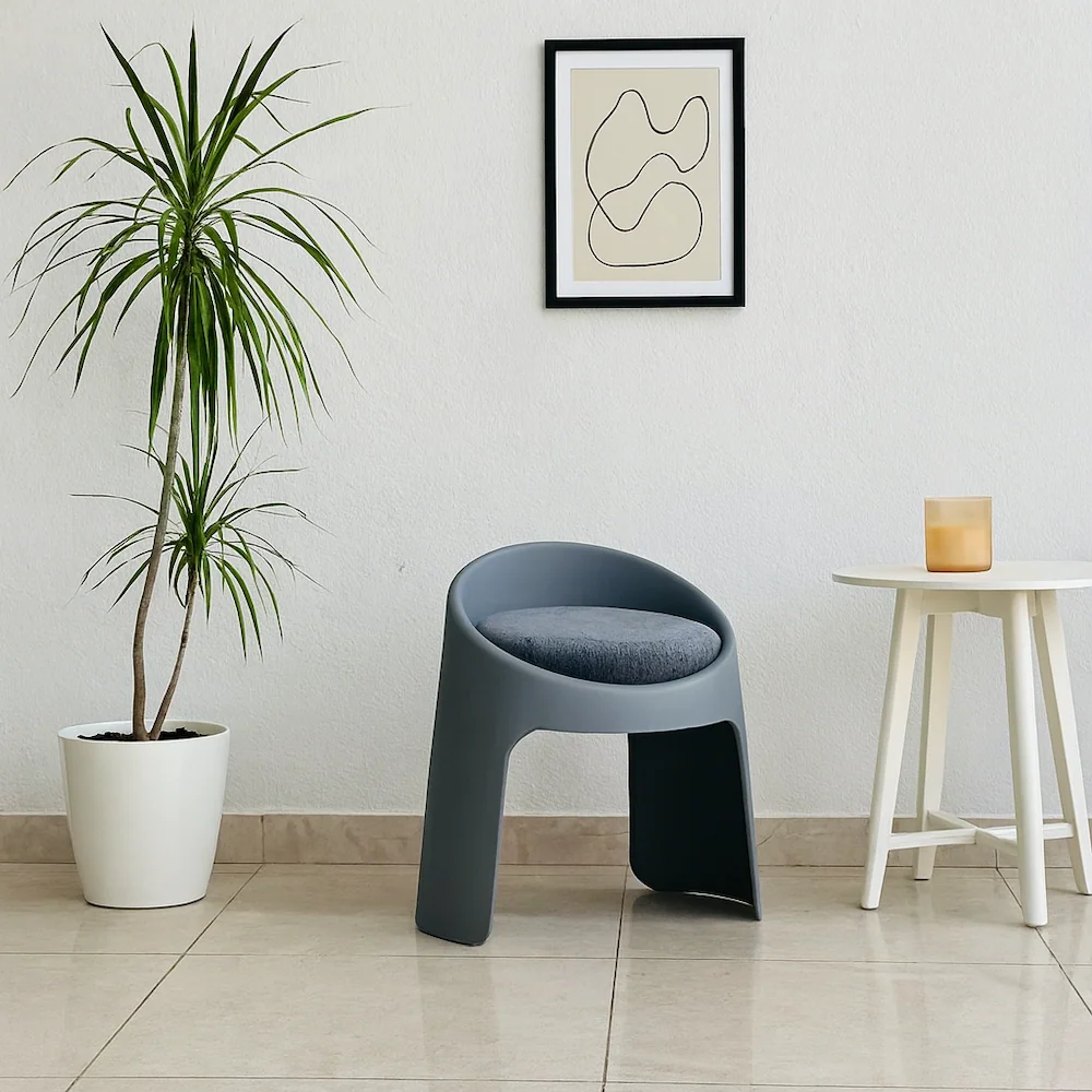 Modern gray chair with round velvet seat and molded plastic base, perfect for interior decor 
