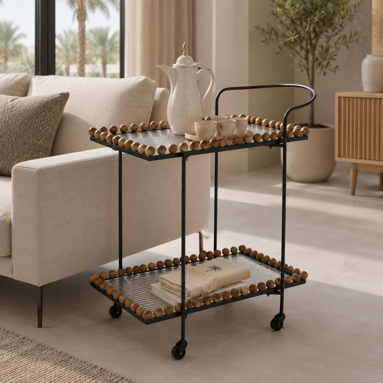  عربة تقديم متعددة الألوان بتصميم أنيق مع أسطح أكريليك وإطار معدني أسود وتفاصيل خرز خشبي من لمسات التأثيث 