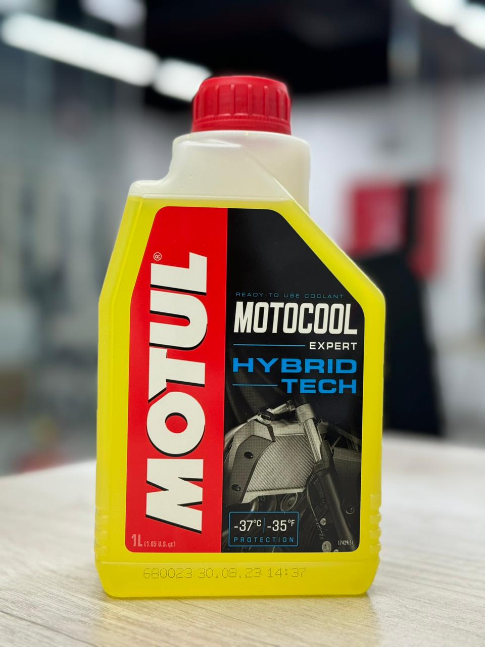 A premium yellow 1-litre plastic bottle with a red cap and black label of Genuine MOTUL