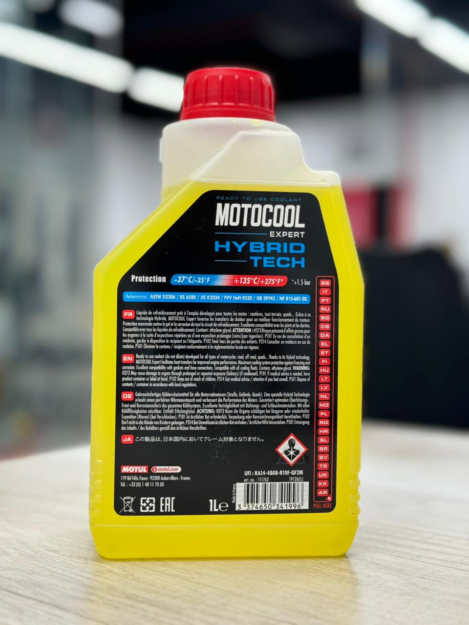 A premium yellow 1-litre plastic bottle with a red cap and black label of Genuine MOTUL