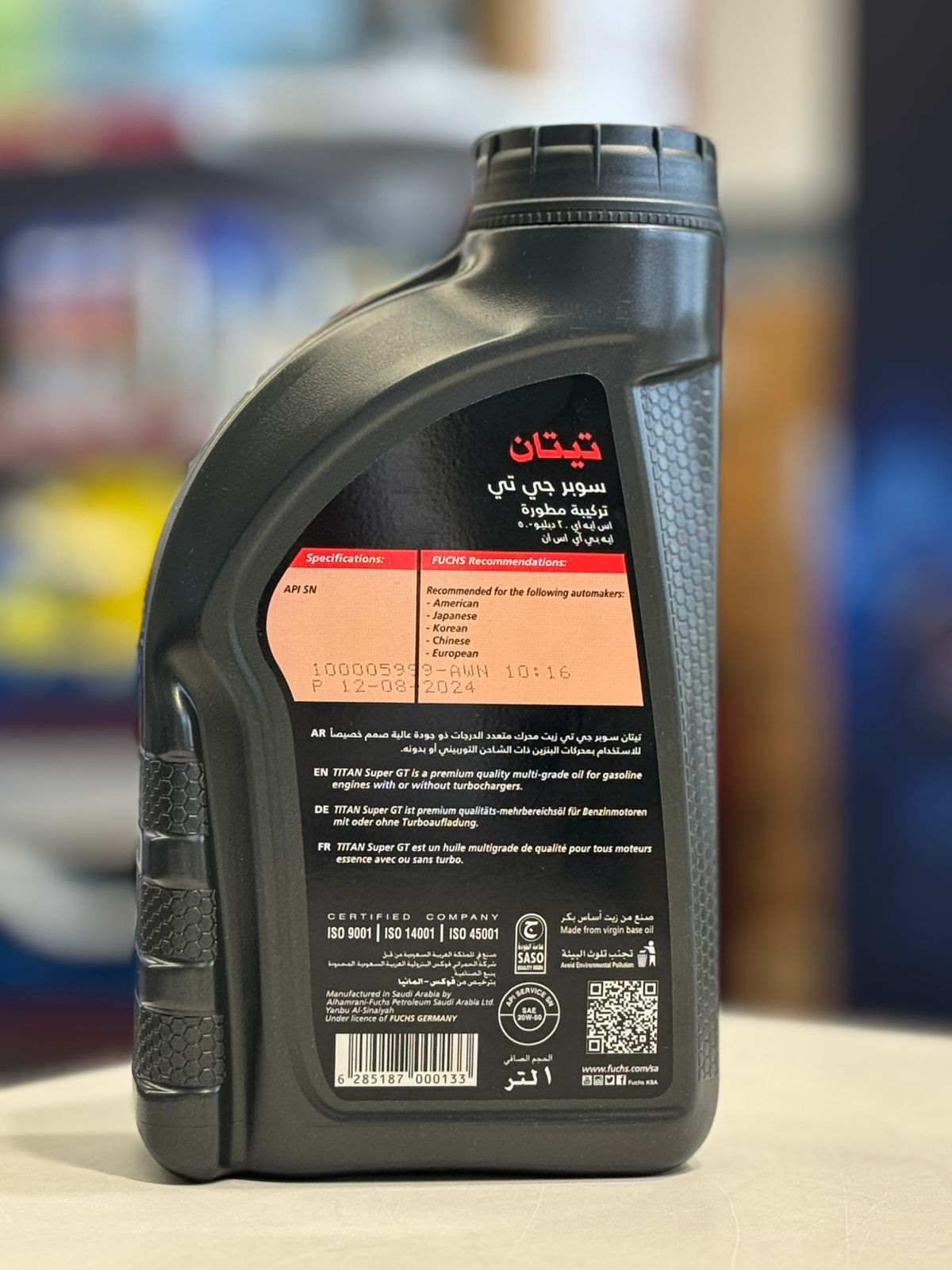 Front view of a 1-liter gray plastic bottle of genuine Fuchs Titan Super GT 20W-50 gasoline engine oil.