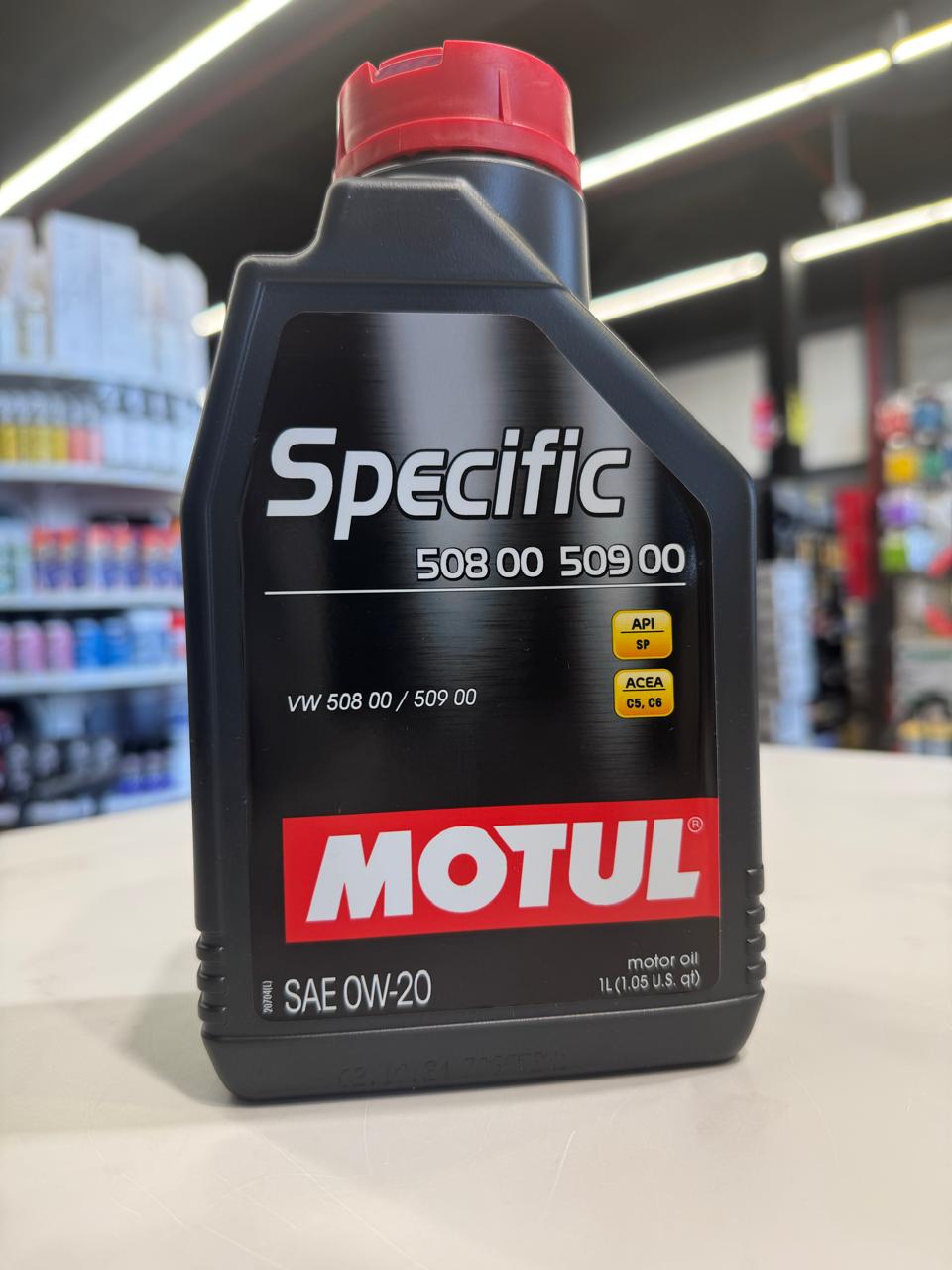 A black plastic bottle of Motul Specific 0W-20 engine oil approved for VW 508 00 509 00