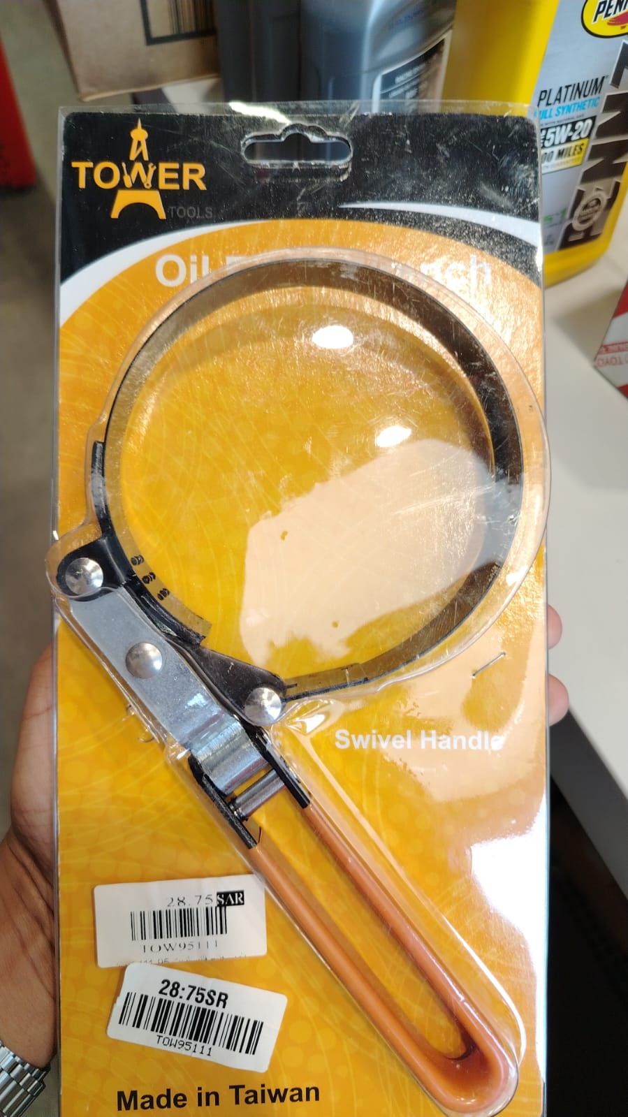 A professional TOWER band oil filter wrench tool featuring a circular flexible black steel strap connected to a solid steel