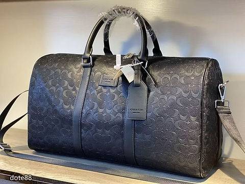 حقيبة سفر COACH بنقشة Signature بارزة وتصميم أنيق مع مساحة واسعة لحمل الأغراض، مزودة بحزام كتف ومقابض مريحة مثالية للسفر والرحلات.