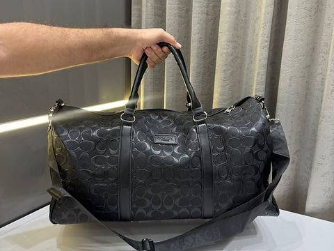 حقيبة سفر COACH بنقشة Signature بارزة وتصميم أنيق مع مساحة واسعة لحمل الأغراض، مزودة بحزام كتف ومقابض مريحة مثالية للسفر والرحلات.