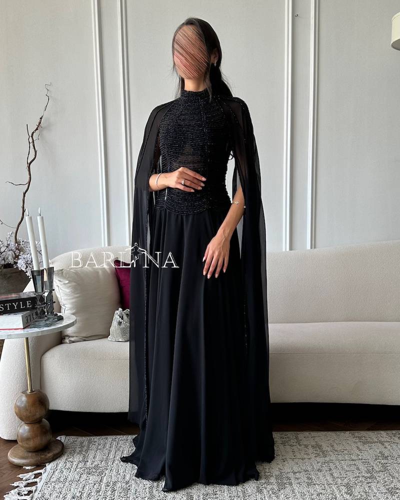 فستان أسود ملكي بفصوص وبأكمام كيب