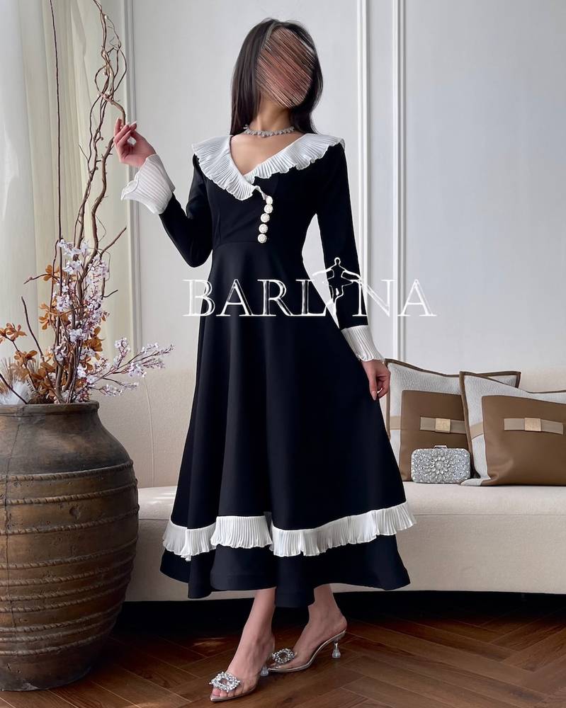 فستان أسود كلاسيكي بأطراف بيضاء مكشكشة