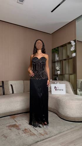 فستان سهرة أسود مرصع بالترتر مع تنورة شراشيب انسيابية ولمسات ذهبية فاخرة