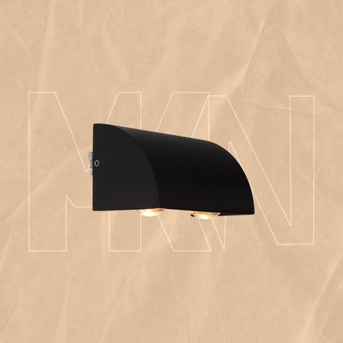 الصورة تُظهر مصباح حائط خارجي (أو داخلي) حديث، لونه أسود مطفأ (Matte Black)، بتصميم نصف أسطواني أو منحني. ويُسلط الضوء من أسفل المصباح على شكل قوسين مضيئين أو نمط ضوئ