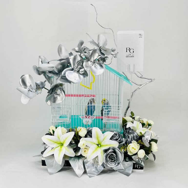 A pair of budgies with a cage decorated with colorful artificial flowers-636