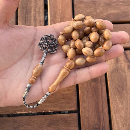 كوك طبيعي (خامة طبيعية) عدد الخرز 33 مقاس 10*14ملي بكركوشة فضة طربزوني من تصميمنا 