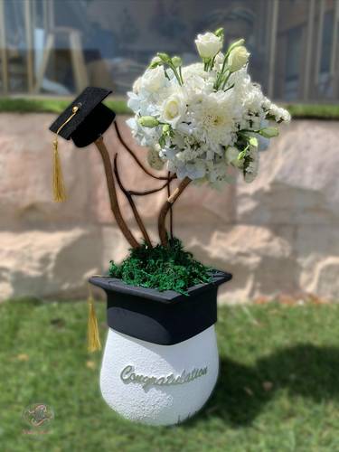 Fresh flower bouquet in a graduation hat vase 