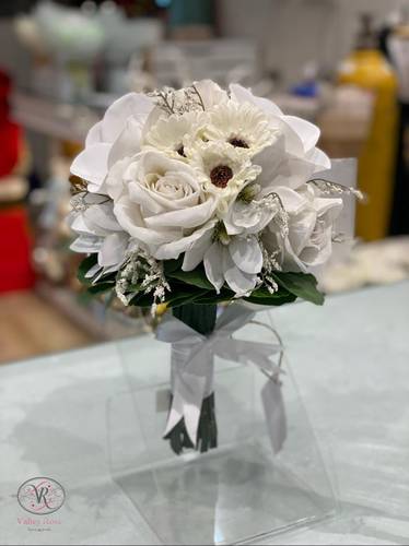  Bridal bouquet of white roses and gerbera flowers, accented with soft fillers and wrapped in an elegant white ribbon – the perfect choice for a graceful bride.