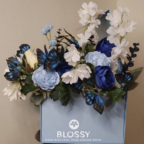  الصندوق الأزرق المزيّن بالورد الصناعي – هدية رمضان الأنيقة صُنع هذا الصندوق بحب ليكون هدية تعبّر عن الاهتمام وتلامس القلب. يأتي بتصميم فاخر باللون الأزرق، مزدانًا بورد صناعي أنيق يمنحه لمسة راقية، ويحتوي على مجموعة مختارة بعناية من أجمل مستلزمات رمضان: محتويات الصندوق: • 	مصحف كريم بتصميم أنيق • 	إسدالة صلاة ناعمة ومريحة • 	سجادة صلاة فاخرة • 	مبخرة زجاجية ذات تصميم راقٍ • 	سبحة إلكترونية لسهولة الذكر • 	نجمة ذهبية مضيئة تضيف أجواء رمضانية دافئة • 	فانوس رمضاني أبيض اللون • 	مجسم خشبي مضيء يحمل عبارة رمضانية جميلة